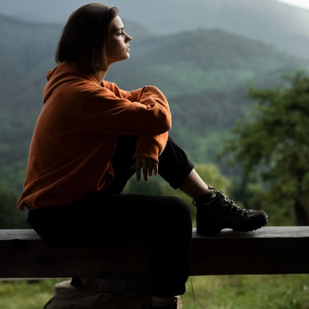 Susimąstęs žmogus ramioje aplinkoje, apmąstantis savo asmeninį tobulėjimą ir vidinę laisvę.